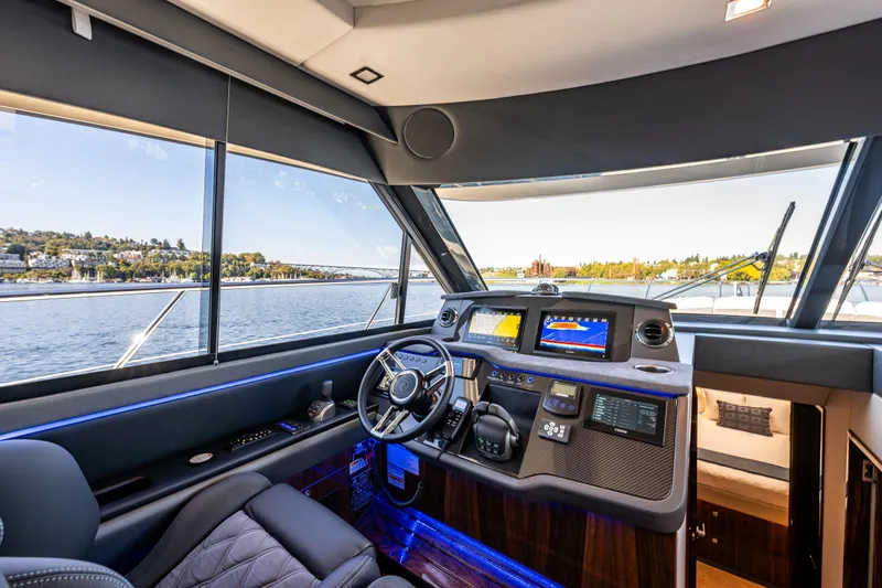 Slide: The Image of Luxurious 2025 Riviera 4600 Sport Yacht helm with advanced navigation systems and scenic water view. - 29