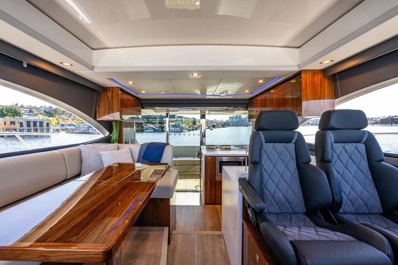 Slide: The Image of 2025 Riviera 4600 Sport Yacht interior with luxurious seating and elegant wood finishes. - 34