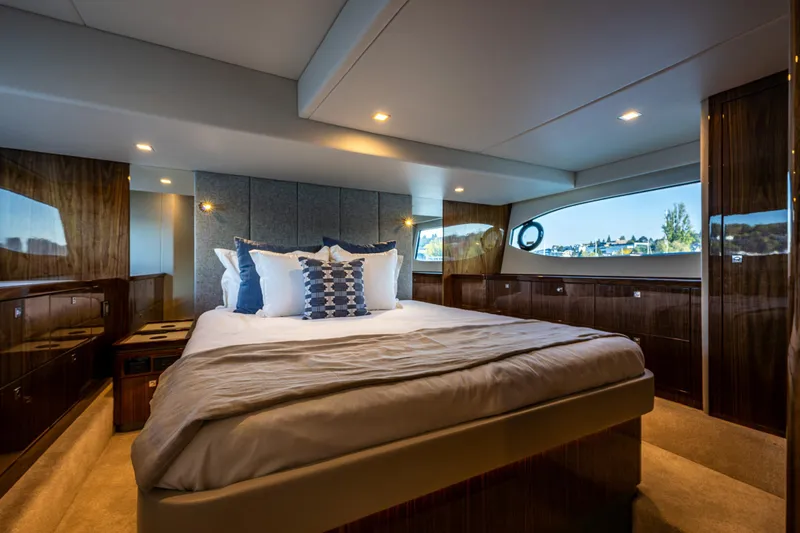 Slide: The Image of Luxurious bedroom interior of 2025 Riviera 4600 Sport Yacht with elegant wood finishes. - 37