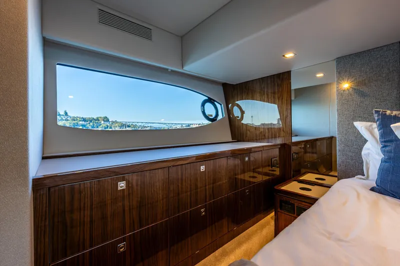 Slide: The Image of Luxurious interior of 2025 Riviera 4600 Sport Yacht with elegant wood finish and scenic window view. - 38