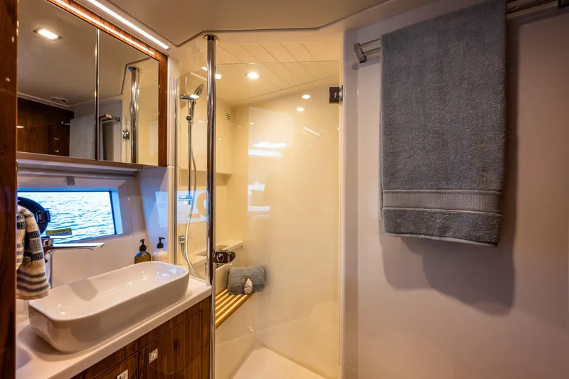 Slide: The Image of Luxurious bathroom in 2025 Riviera 4600 Sport Yacht with modern fixtures and ocean view. - 42