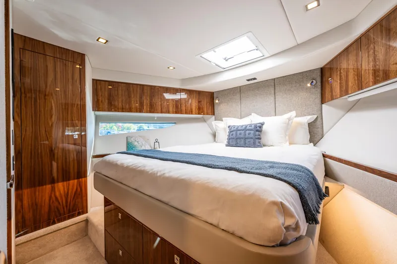 Slide: The Image of Luxurious bedroom interior of 2025 Riviera 4600 Sport Yacht with elegant wood finishes. - 43