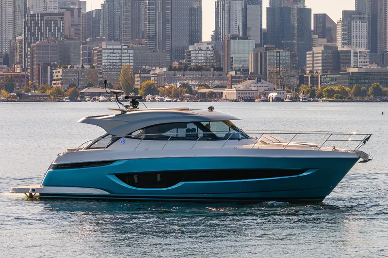 Slide: The Image of 2025 Riviera 4600 Sport Yacht cruising near city skyline. - 57