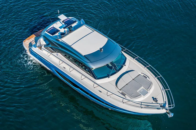 Slide: The Image of 2025 Riviera 4600 Sport Yacht cruising on open water, aerial view. - 6