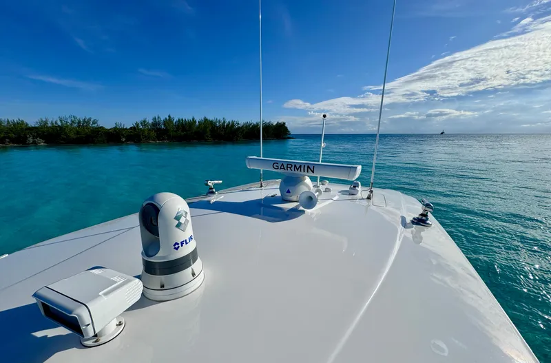 Slide: The Image of 2023 Intrepid 427 Nomad SE boat on clear blue water, featuring Garmin equipment. - 11