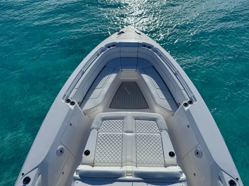 Slide: The Image of 2023 Intrepid 427 Nomad SE boat on clear blue water, showcasing luxurious seating. - 15