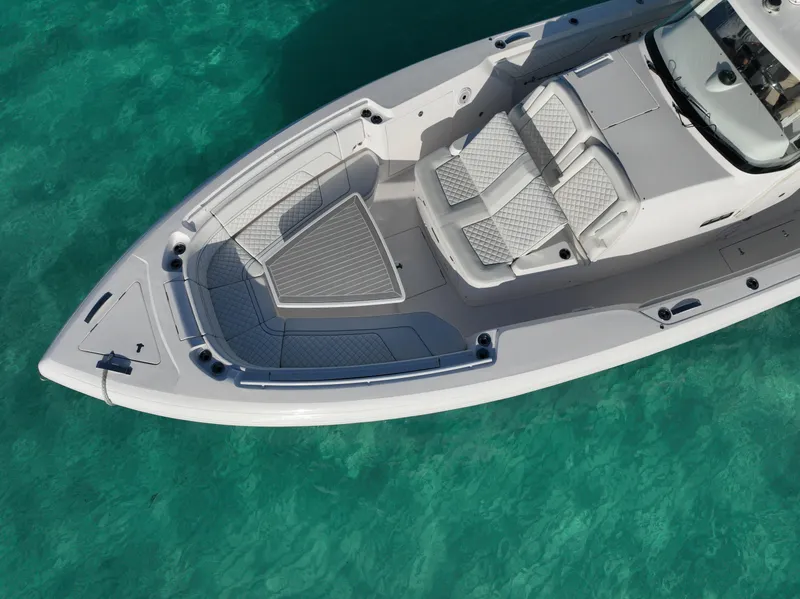 Slide: The Image of 2023 Intrepid 427 Nomad SE boat on clear turquoise water, aerial view. - 23