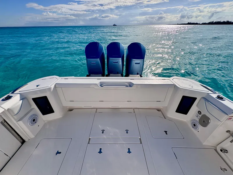 Slide: The Image of 2023 Intrepid 427 Nomad SE boat with triple engines on clear blue water. - 5