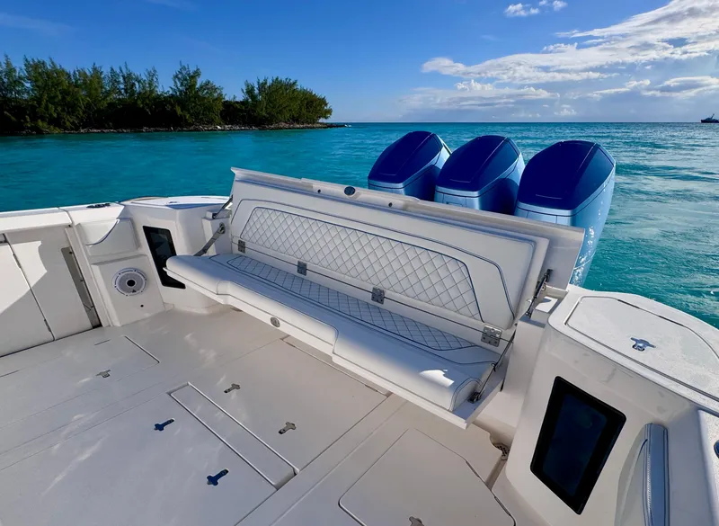 Slide: The Image of 2023 Intrepid 427 Nomad SE boat with triple engines on turquoise water. - 6