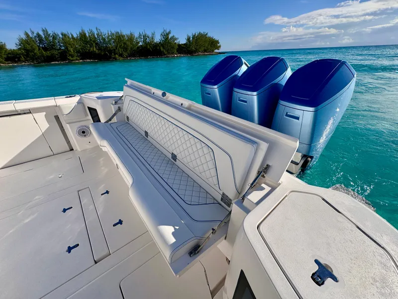 Slide: The Image of 2023 Intrepid 427 Nomad SE boat with triple engines on turquoise water. - 7