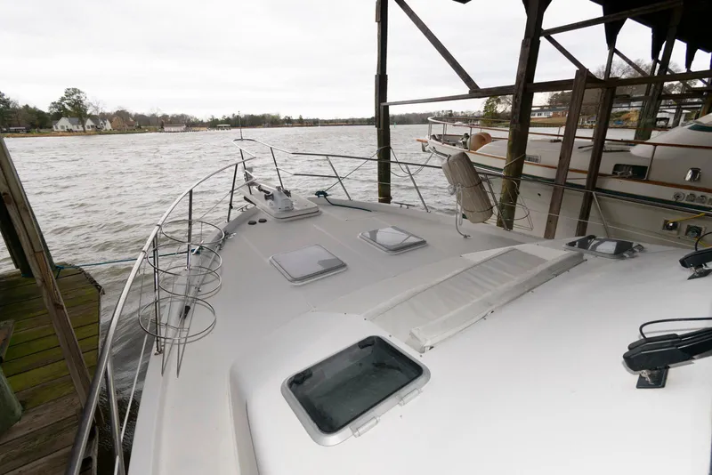 Slide: The Image of 1998 Bayliner 4788 Pilot House Motoryacht docked by a scenic waterfront. - 11