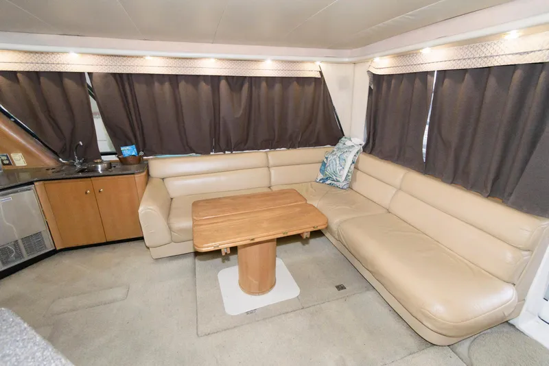 Slide: The Image of 1998 Bayliner 4788 Pilot House Motoryacht interior with beige leather seating and wooden table. - 13