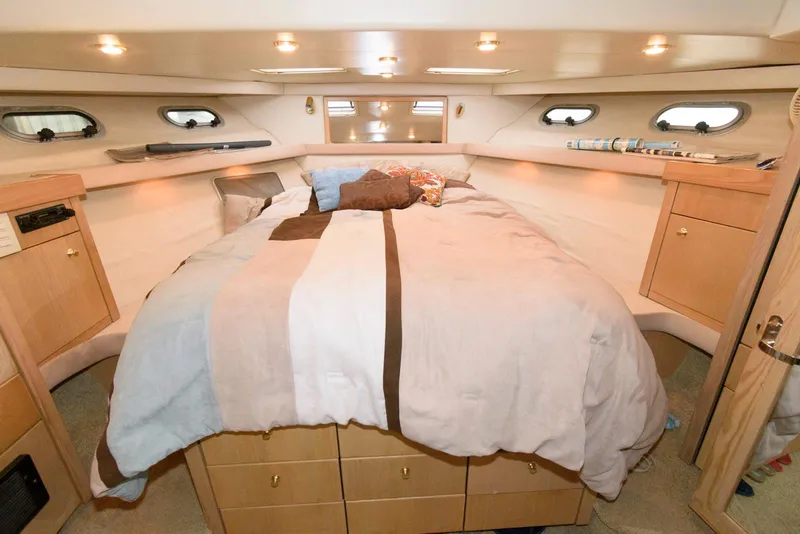 Slide: The Image of 1998 Bayliner 4788 Pilot House Motoryacht bedroom with cozy bed and wooden cabinetry. - 16
