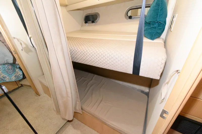 Slide: The Image of Bunk beds in 1998 Bayliner 4788 Pilot House Motoryacht cabin, featuring cozy bedding and curtains. - 19