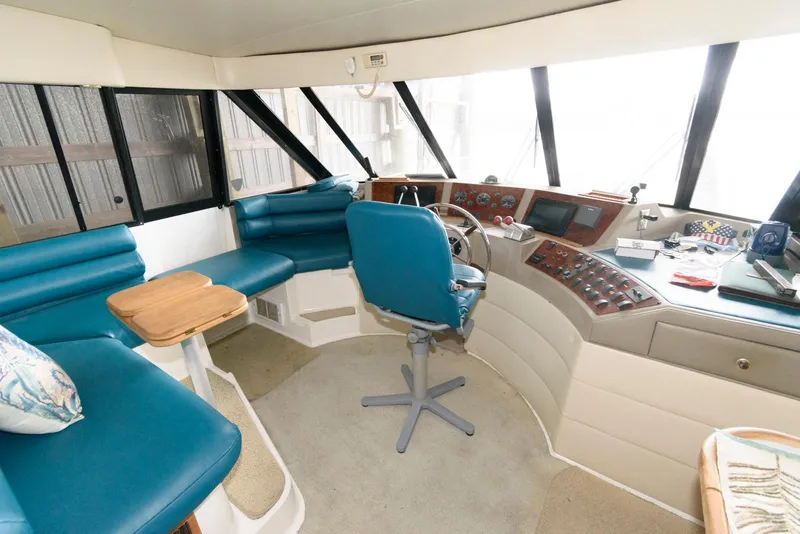 Slide: The Image of 1998 Bayliner 4788 Pilot House Motoryacht interior with blue seating and navigation controls. - 21