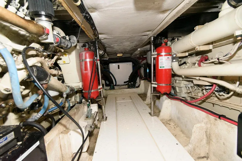 Slide: The Image of Engine room of 1998 Bayliner 4788 Pilot House Motoryacht with fire extinguishers and piping. - 24