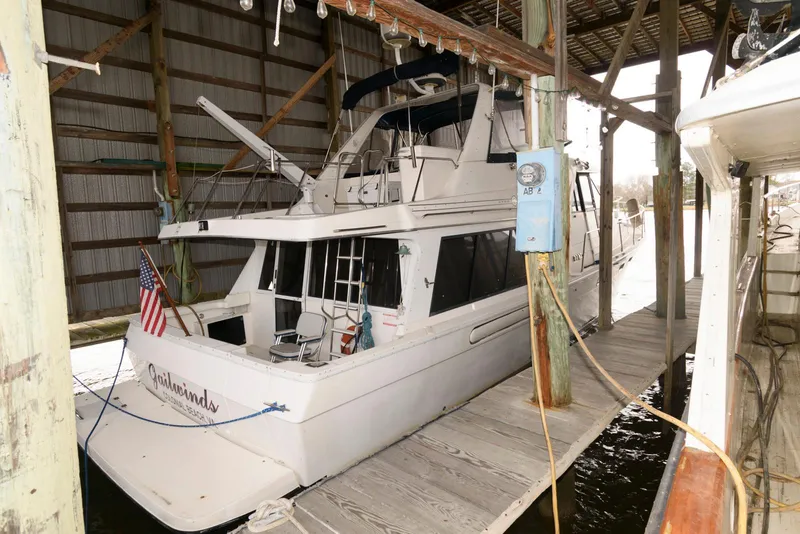 Slide: The Image of 1998 Bayliner 4788 Pilot House Motoryacht docked in a covered marina slip. - 3