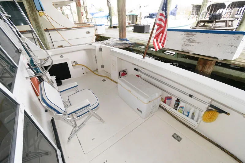 Slide: The Image of 1998 Bayliner 4788 Pilot House Motoryacht deck with seating and American flag. - 5