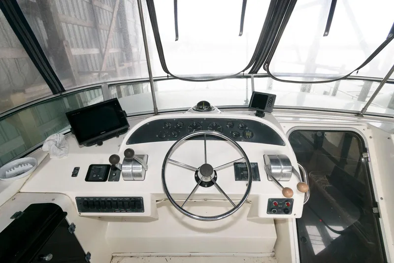 Slide: The Image of 1998 Bayliner 4788 Pilot House Motoryacht helm with steering wheel and navigation controls. - 9