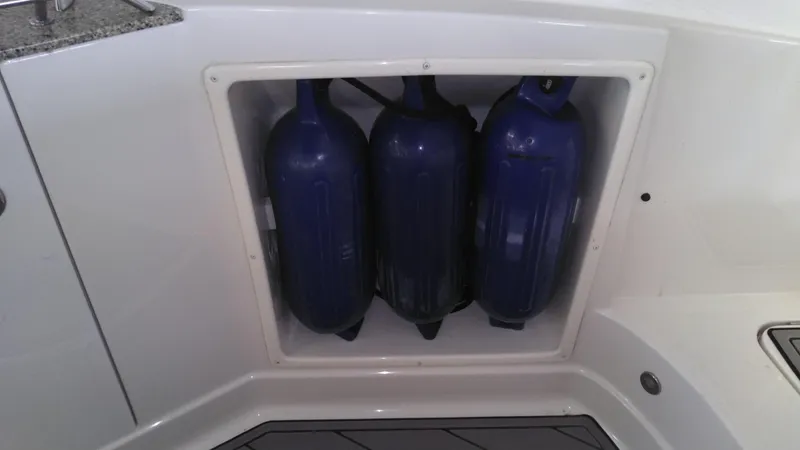 Slide: The Image of Storage compartment with blue fenders on a 2008 Monterey 254 FS boat. - 16