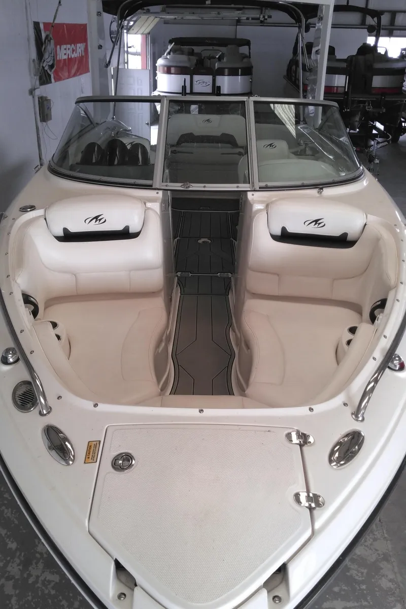 Slide: The Image of 2008 Monterey 254 FS boat with white seating and sleek design in a showroom. - 27