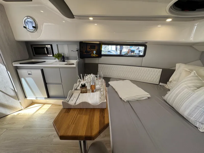 Slide: The Image of Luxurious interior of 2025 Hanover 387 yacht with kitchenette, bed, and wooden table. - 4