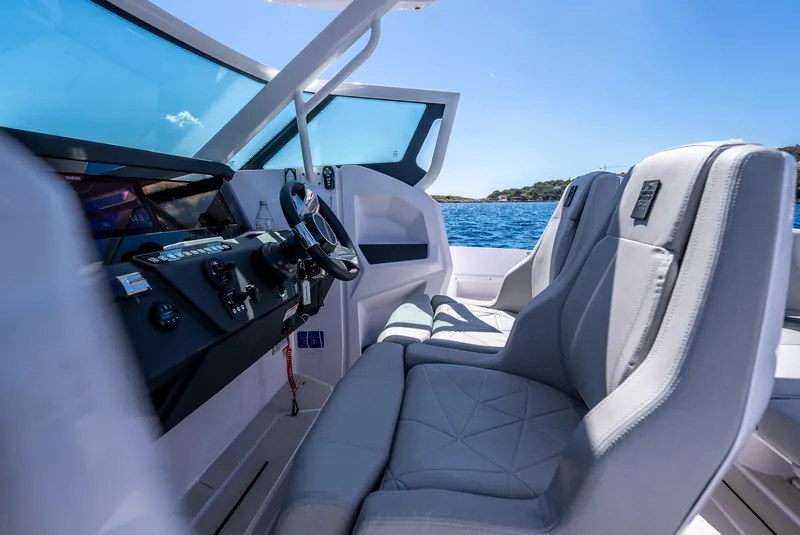 Slide: The Image of 2025 Axopar 29 Sun-Top boat interior with seating, ocean view, and modern design. - 11