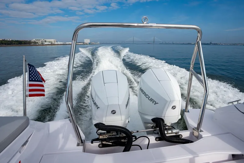 Slide: The Image of 2025 Axopar 29 Sun-Top boat with dual Mercury engines cruising on open water. - 14