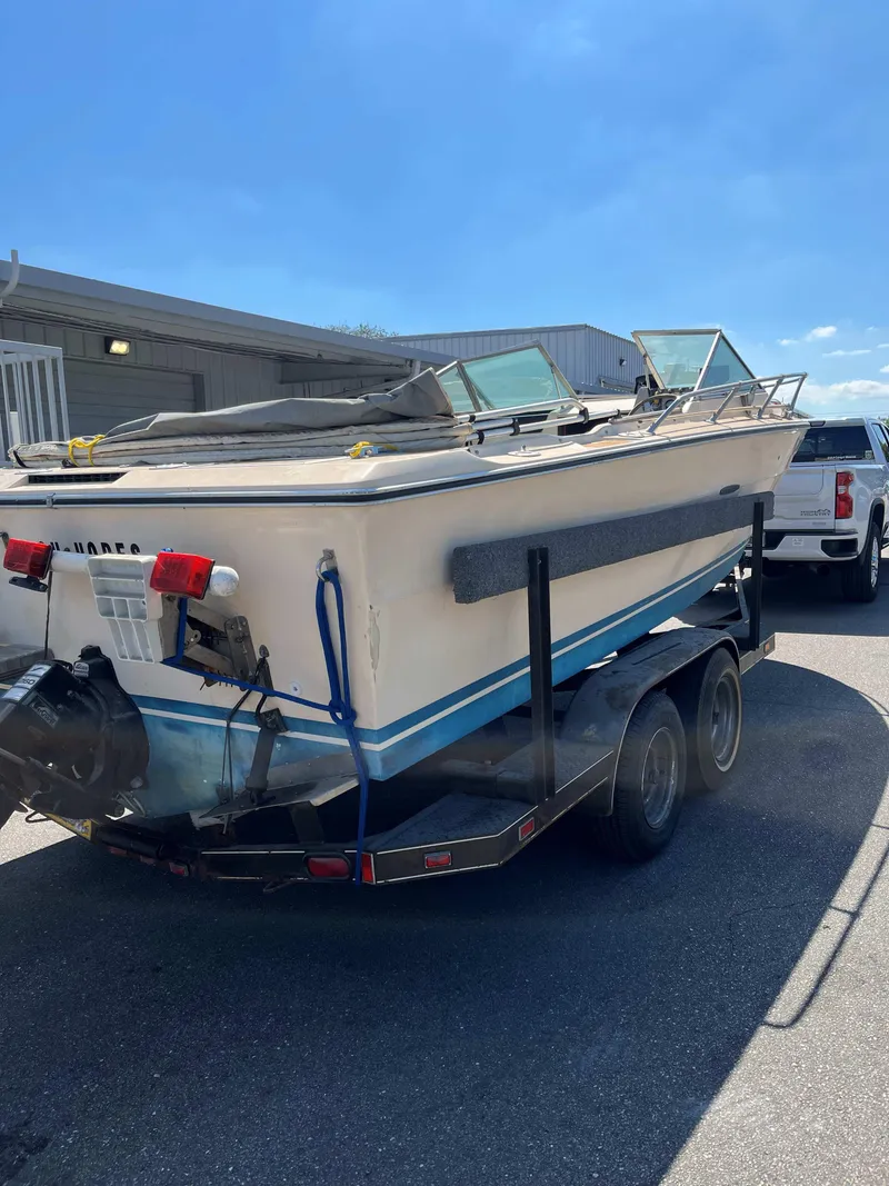 Slide: The Image of 1974 Sea Ray SRV 220 CC boat on trailer, parked outdoors under clear blue sky. - 3