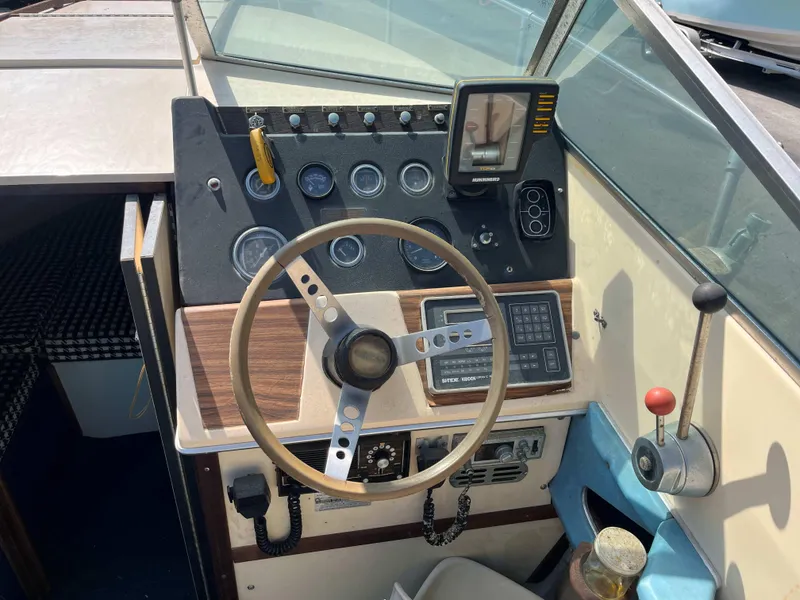 Slide: The Image of 1974 Sea Ray SRV 220 CC boat dashboard with steering wheel and control panel. - 7