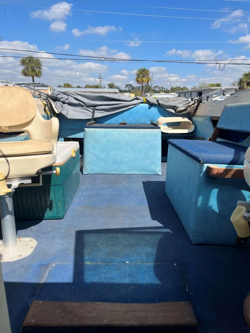 Slide: The Image of 1974 Sea Ray SRV 220 CC boat interior with blue seating and clear sky background. - 8