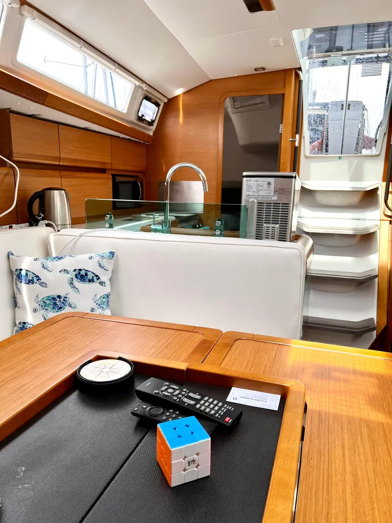 Slide: The Image of Interior of 2018 Jeanneau Sun Odyssey 419 yacht, featuring modern kitchen and cozy seating area. - 12