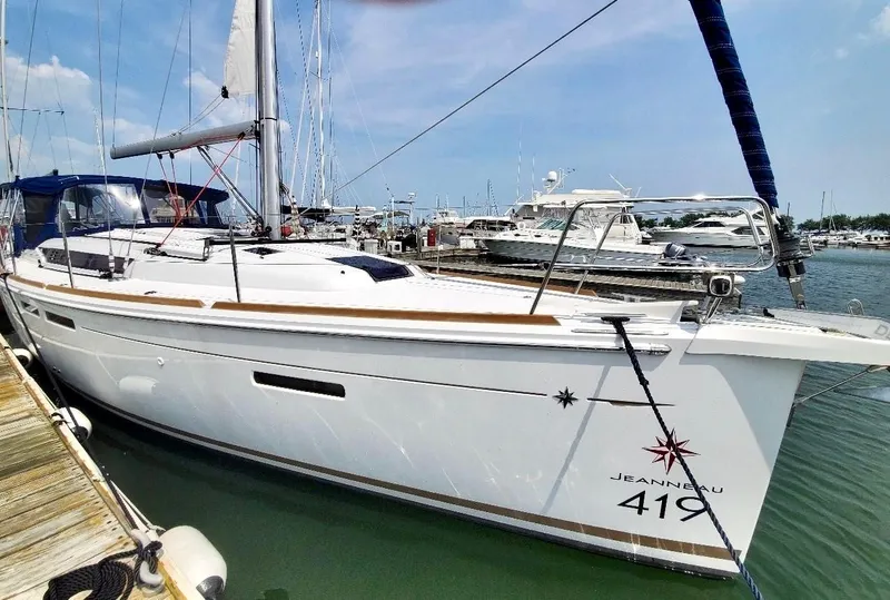 Slide: The Image of 2018 Jeanneau Sun Odyssey 419 sailboat docked in a marina. - 3