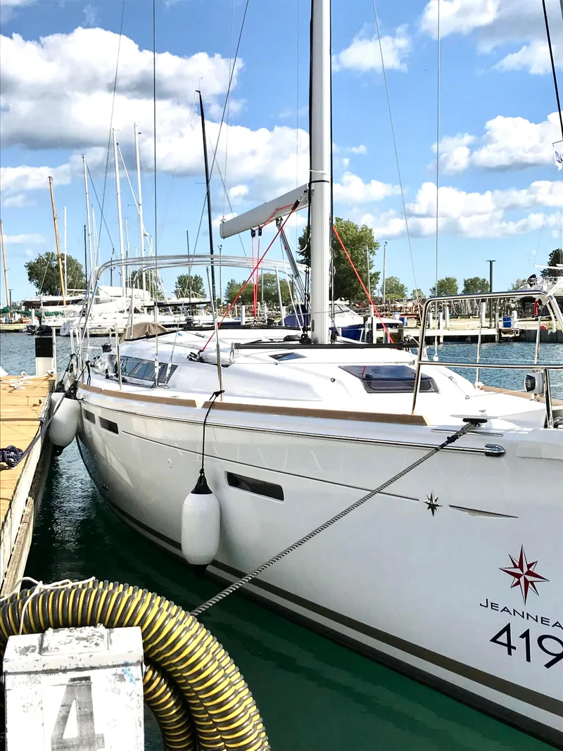 Slide: The Image of 2018 Jeanneau Sun Odyssey 419 yacht docked at marina under blue sky. - 4