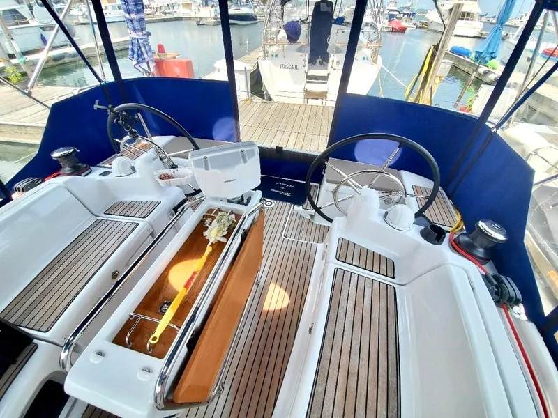 Slide: The Image of 2018 Jeanneau Sun Odyssey 419 cockpit with dual steering wheels and teak flooring. - 8