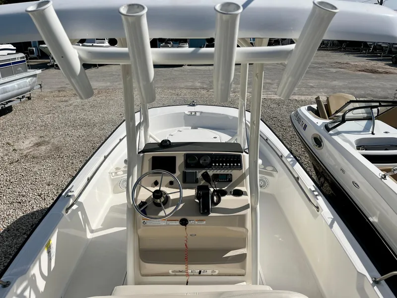 Slide: The Image of 2023 Boston Whaler 210 Montauk boat interior with steering console and rod holders. - 14