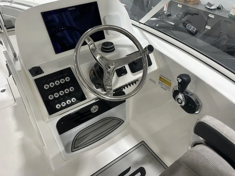 Slide: The Image of 2025 Sea Pro 240 Dual Console boat dashboard with steering wheel and control panel. - 10