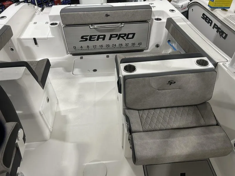 Slide: The Image of 2025 Sea Pro 240 Dual Console boat interior with gray seating and branded details. - 12