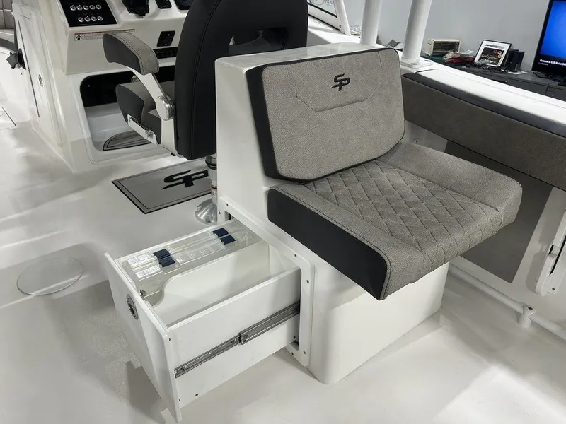 Slide: The Image of 2025 Sea Pro 240 Dual Console interior with cushioned seating and storage drawer. - 13