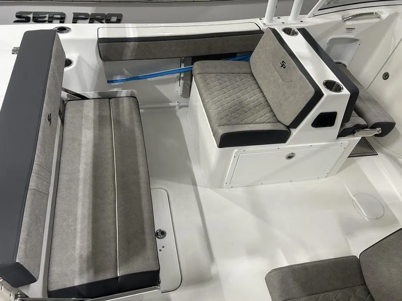 Slide: The Image of 2025 Sea Pro 240 Dual Console boat interior with gray seating and cup holders. - 15