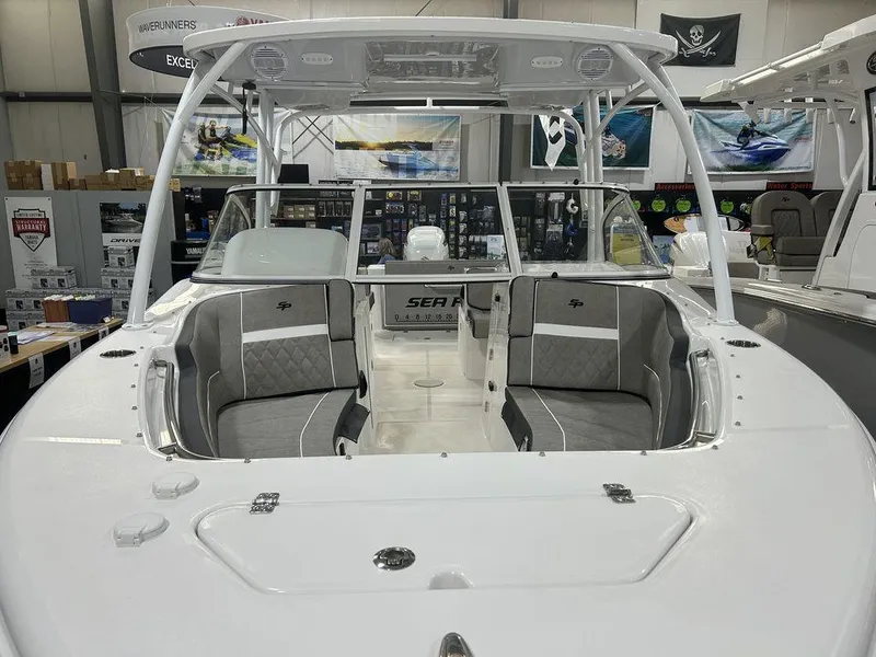 Slide: The Image of 2025 Sea Pro 240 Dual Console boat interior with gray seating, displayed in showroom. - 8
