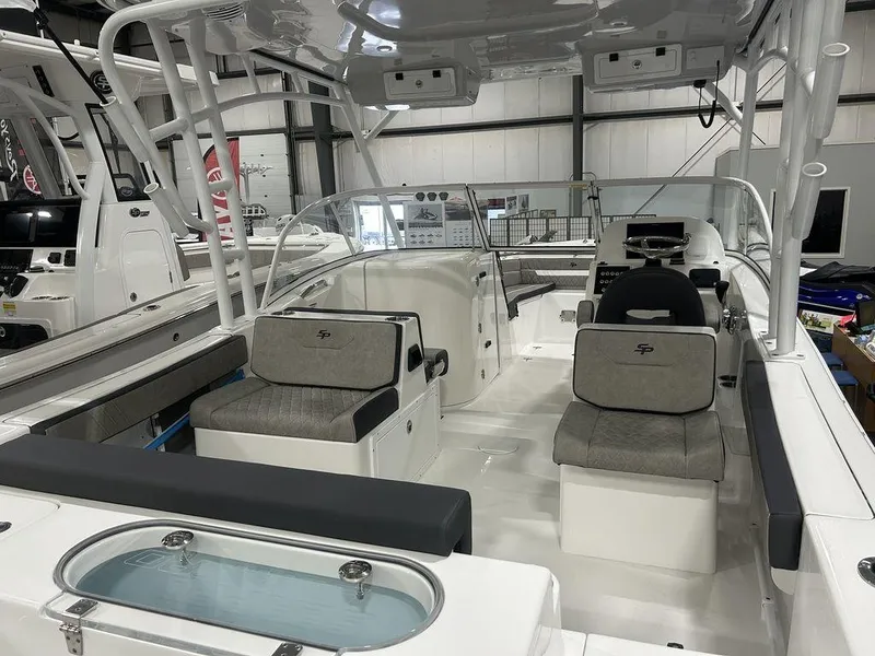 Slide: The Image of 2025 Sea Pro 240 Dual Console boat interior with seating and helm, showcased indoors. - 9