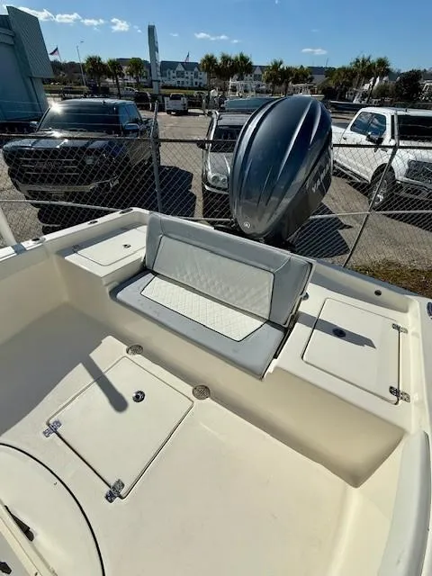 Slide: The Image of 2025 Avenger AV26 boat interior with seating and motor, parked outdoors. - 10