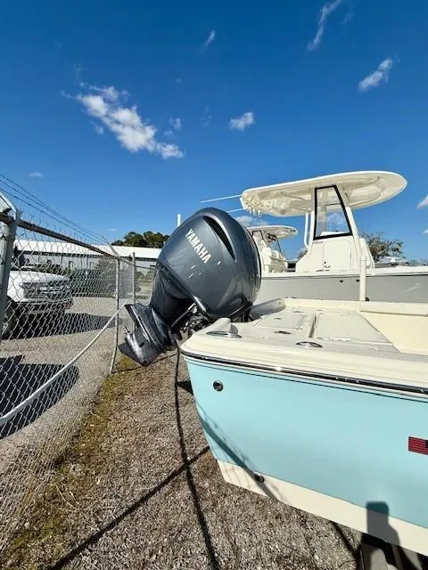 Slide: The Image of 2025 Avenger AV26 boat with Yamaha outboard motor, parked outdoors under a clear blue sky. - 2