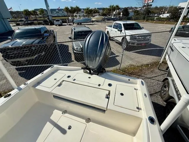 Slide: The Image of Avenger AV26 boat, 2025 model, with outboard motor, parked near vehicles and fence. - 9