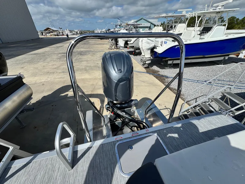 Slide: The Image of 2025 Bennington 22 SSB boat with outboard motor, docked under a cloudy sky. - 7