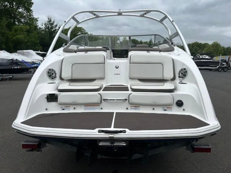 Slide: The Image of 2014 Yamaha Boats 242 Limited S with galvanized trailer, rear view, showcasing seating and speakers. - 8