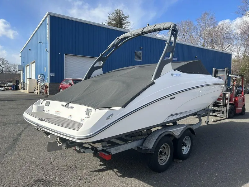 Slide: The Image of 2017 Yamaha Boats 212 Limited S on trailer, parked outside a blue warehouse. - 11