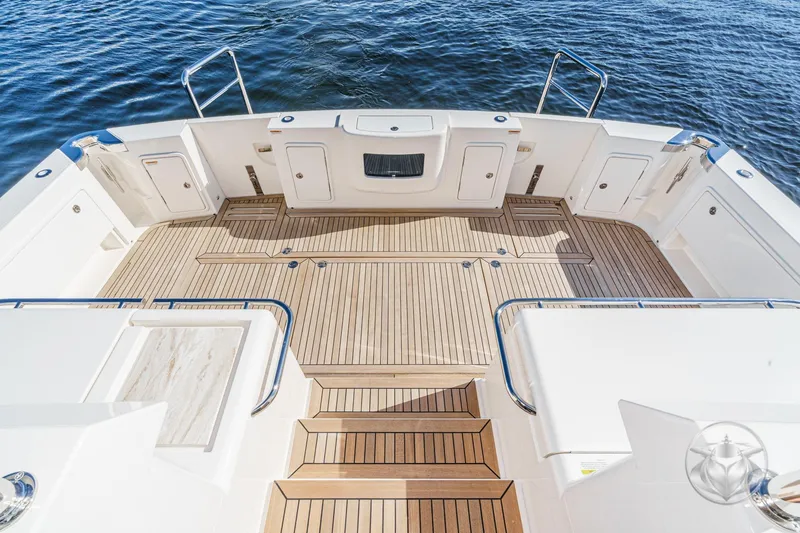 Slide: The Image of 2026 Riviera 58 Sports Motor Yacht deck with elegant wood finish and ocean view. - 18