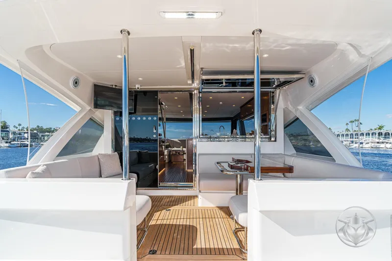 Slide: The Image of 2026 Riviera 58 Sports Motor Yacht, luxurious deck view with elegant seating and scenic marina backdrop. - 22